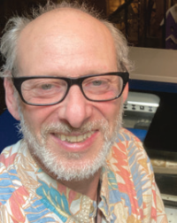 Smiling man with glasses and floral shirt