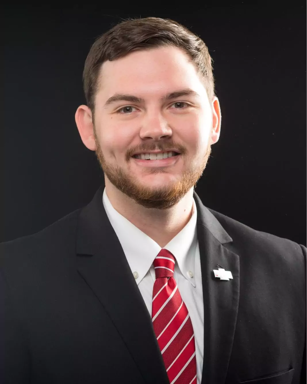 ethan barnes Smiling man in suit and red tie