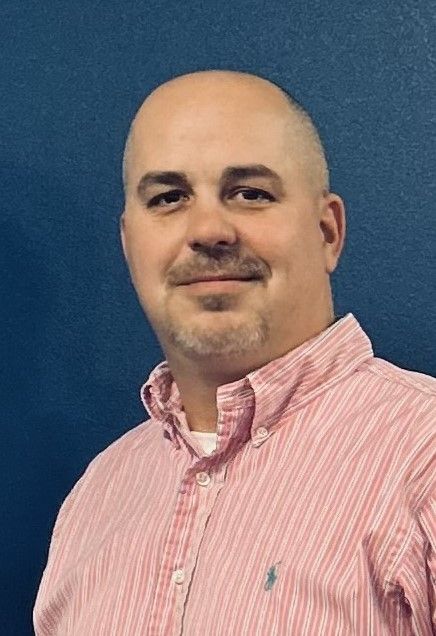 joshua alexander Man in striped shirt against blue background