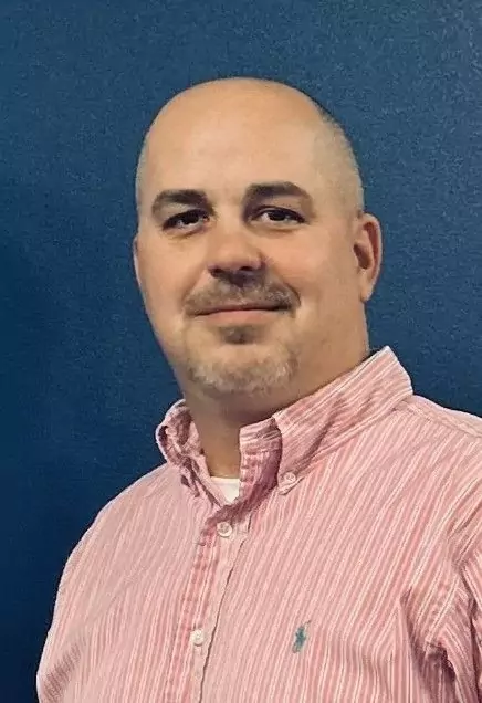 joshua alexander Man in striped shirt against blue background