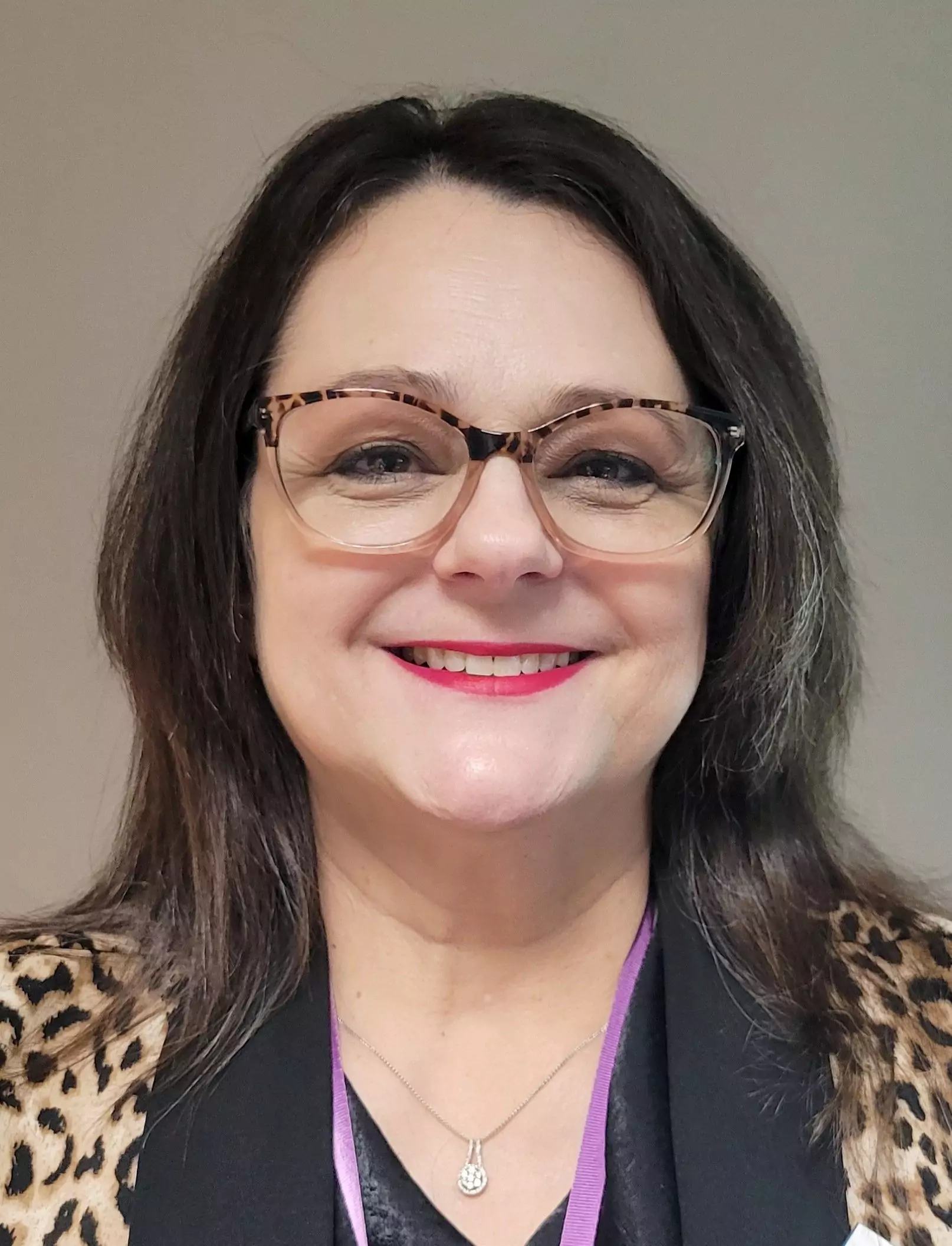 suzzonne norris Smiling person with glasses and leopard print outfit.