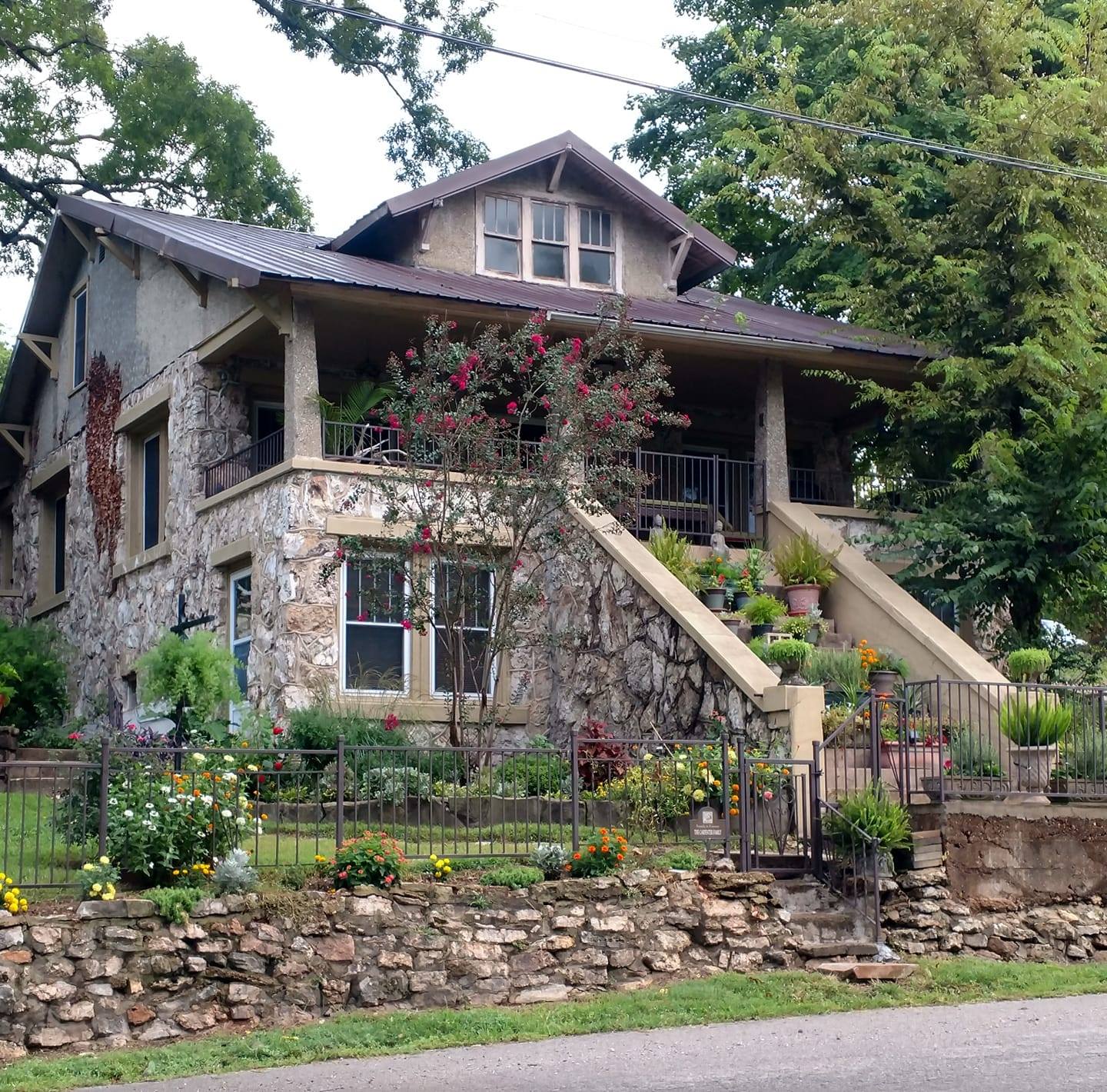 hardyhousevacationrental Charming stone house with lush garden and steps.