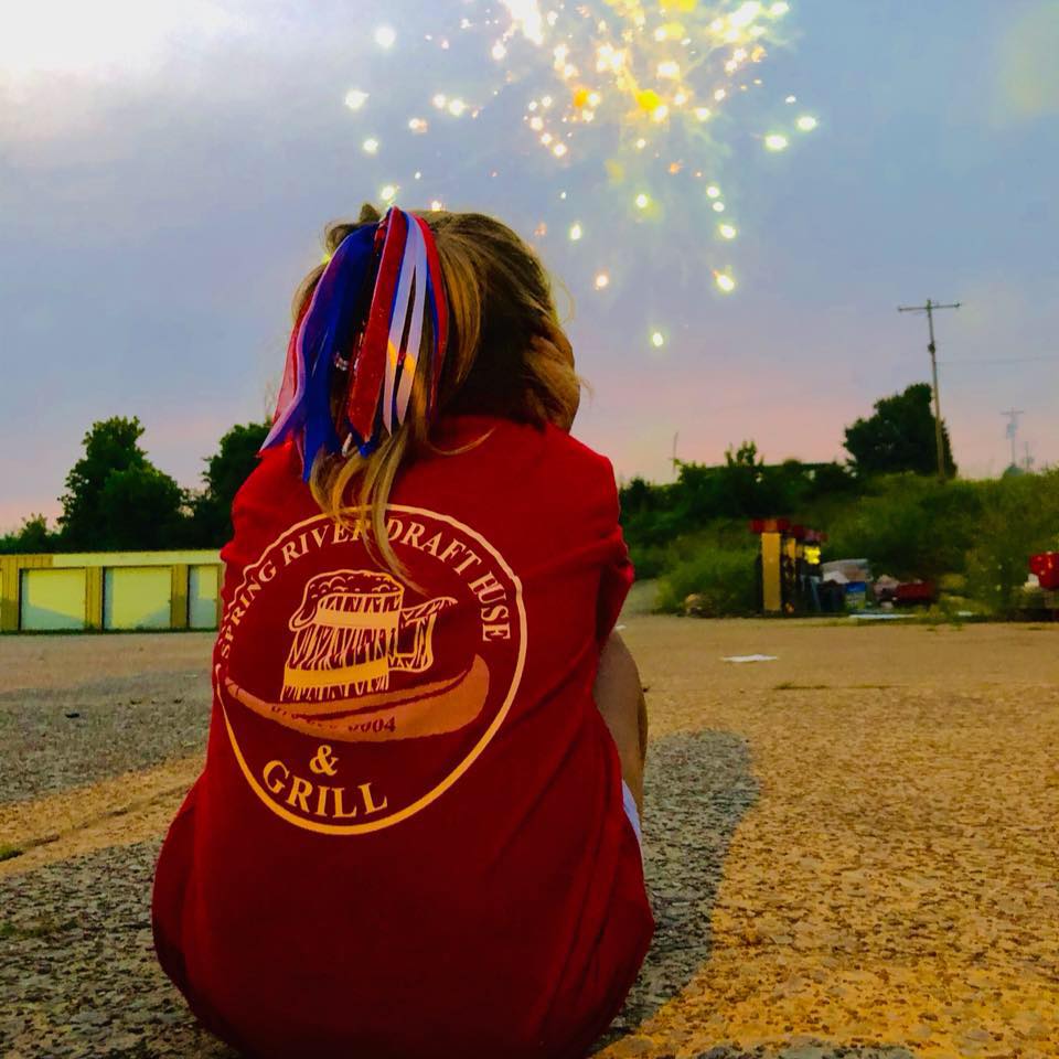 springriverdrafthouse Child watching fireworks during sunset celebration.